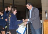 Assembly member Rudy Salas praises Trinity Jones at annual Future Farmers of America conference.